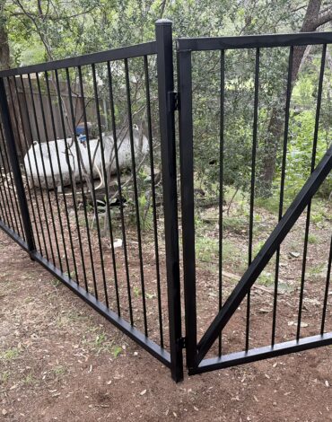 Steel driveway gate stuck open on an Austin Texas property needing repair