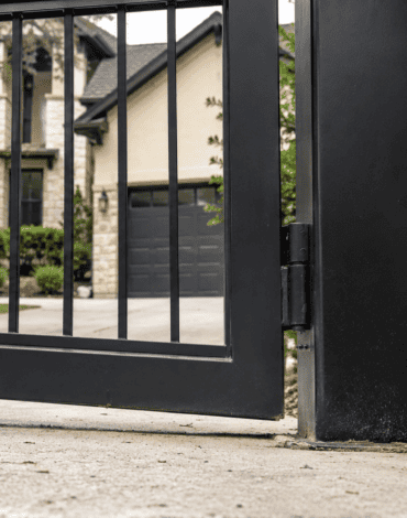 Sagging black steel driveway gate with hinge post issue at an Austin residential home