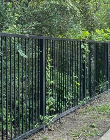Custom steel privacy fence installed around a residential property in Austin, Texas.